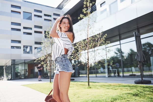 Belle fille avec un sac à dos, marchant le long de la rue de la ville par un matin ensoleillé