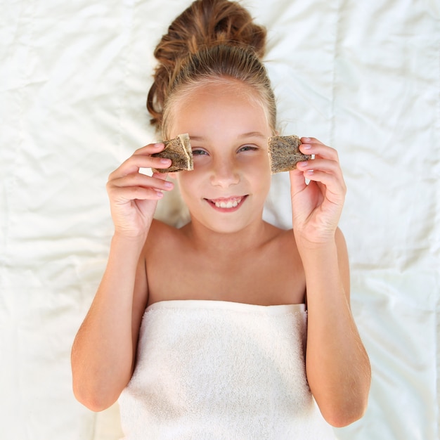 Photo belle fille avec des sachets de thé sur les yeux. vue de dessus.