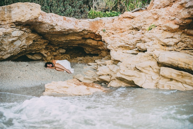 belle fille se trouve dans un canyon de pierre sur la plage, Grèce