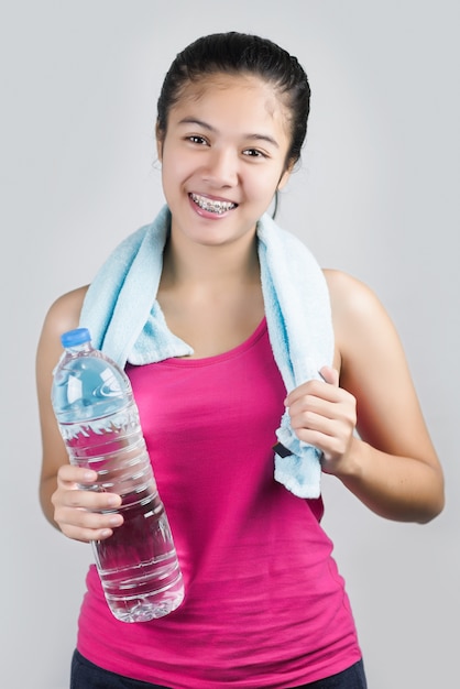 Belle fille avec une serviette et une bouteille d&#39;eau