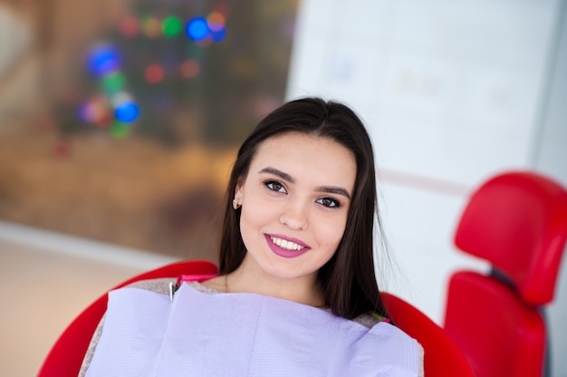 Belle fille souriante dans le fauteuil dentaire.