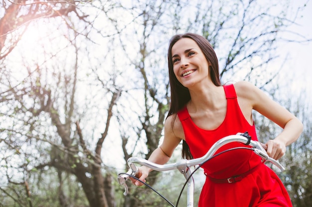 Belle fille souriante fait du vélo dans le parc