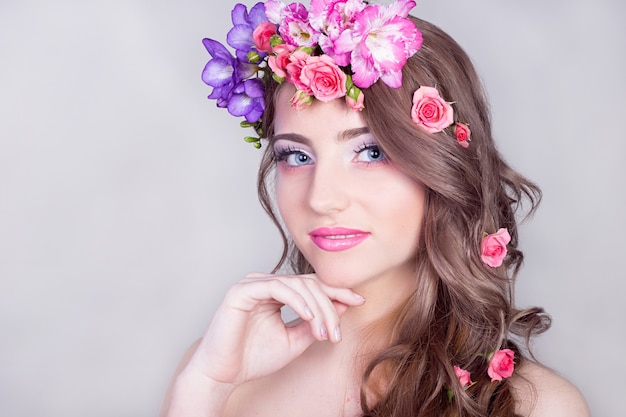 Belle fille souriante avec des fleurs dans les cheveux