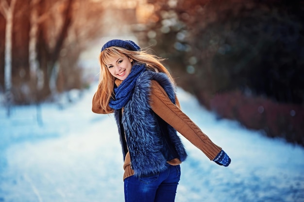 Belle fille souriante heureuse portant un bonnet et des gants de chandail jeune femme se sentant heureuse et