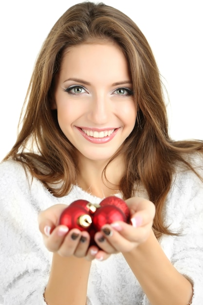 Belle fille souriante avec des jouets de Noël isolés sur blanc