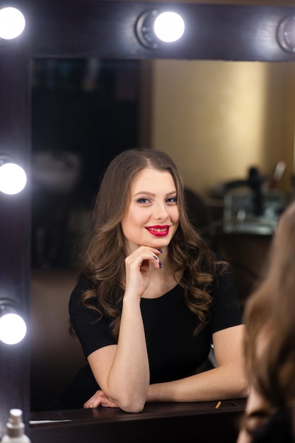 Belle fille souriante et regardant dans le miroir