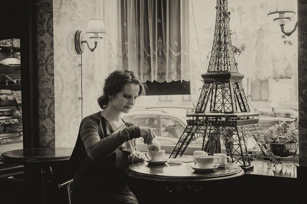 Photo belle fille avec une tasse de café dans un café avec une touche de sépia