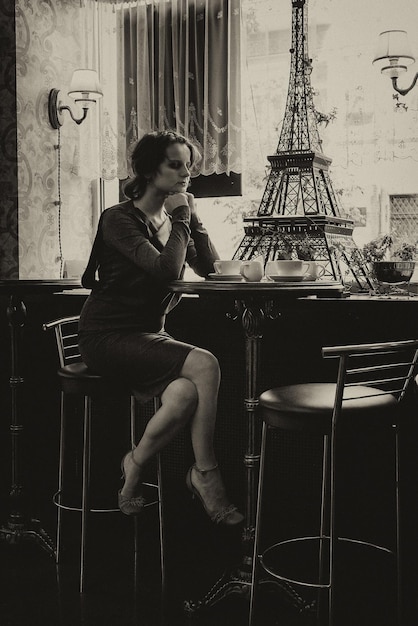 Photo belle fille avec une tasse de café dans un café avec une touche de sépia