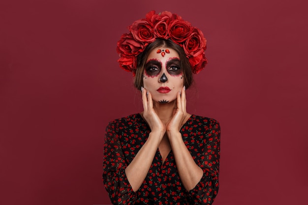 Belle fille en tenue de la muerta et maquillage du crâne à la recherche d'appareil photo pendant l'halloween