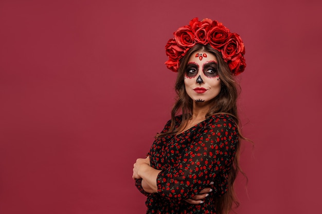 Belle fille en tenue de la muerta et maquillage du crâne à la recherche d'appareil photo pendant l'halloween