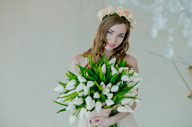 Belle fille tient un bouquet de fleurs.