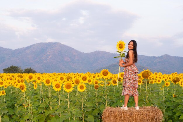 La belle fille tient le tournesol avec une belle fleur déposée