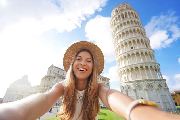 Belle fille touristique prend une photo de selfie avec la tour penchée de Pise sur la place de la cathédrale Pise Toscane Italie