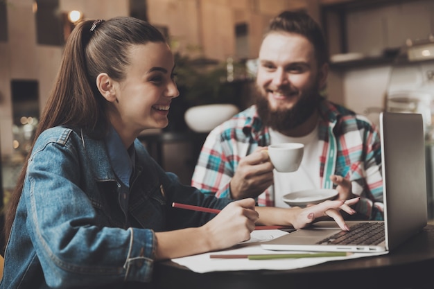 Belle fille travaillant derrière un ordinateur portable dans un café