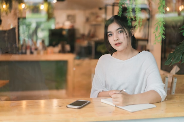 Belle fille travaillant sur la table dans le café