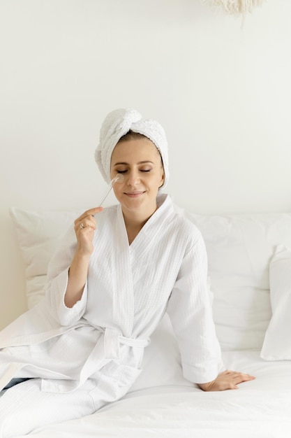 Une belle fille utilise darsonval pour son visage. soins du visage à domicile. cosmétologie du visage