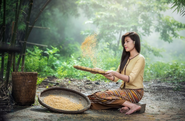 Belle fille vannant le riz séparer entre le riz et la balle de riz, campagne de la Thaïlande