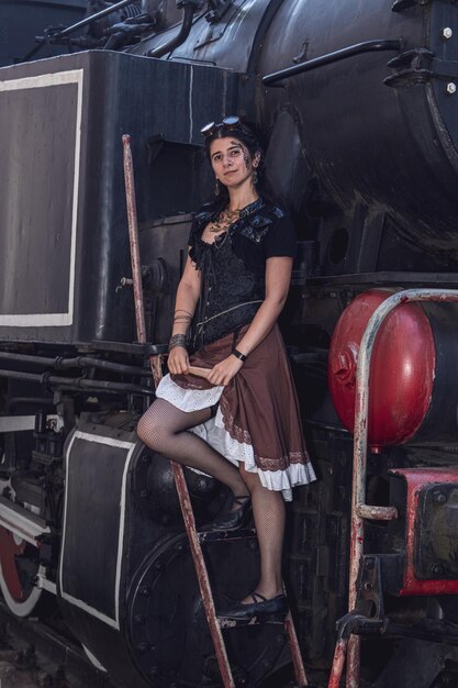 Belle fille en vêtements steampunk sur le fond du train