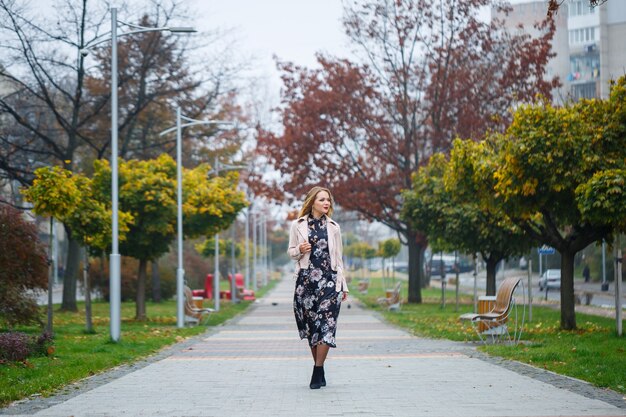 Belle fille vêtue d'une robe dans une ruelle de la ville