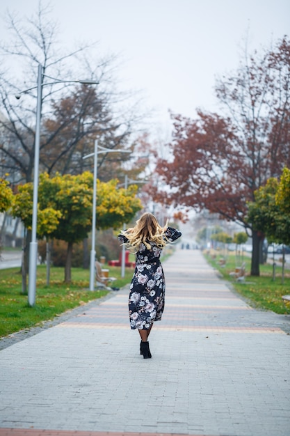 Belle fille vêtue d'une robe dans une ruelle de la ville