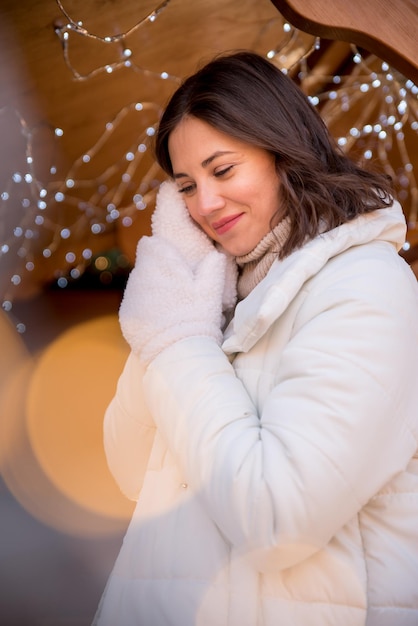 Belle fille vêtue d'une veste blanche et d'un chapeau blanc la fille sourit tasse de café à la main maison d'été en bois fille se réjouit des émotions