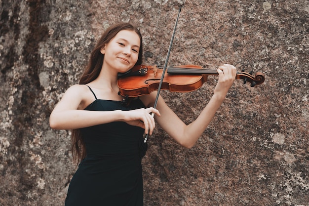 Belle fille avec violon souriant dans la nature. photo de haute qualité