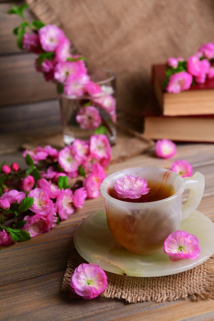 Belle fleur de fruit avec une tasse de thé sur la table sur fond gris