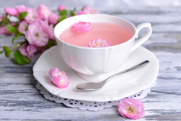 Belle fleur de fruit avec une tasse de thé sur la table libre