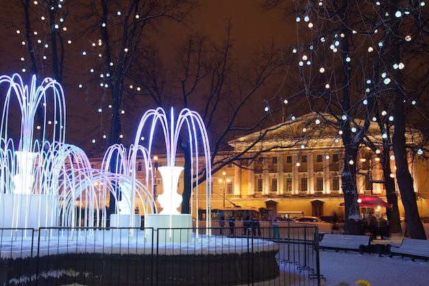 Belle fontaine avec éclairage du soir en hiver dans la ville.