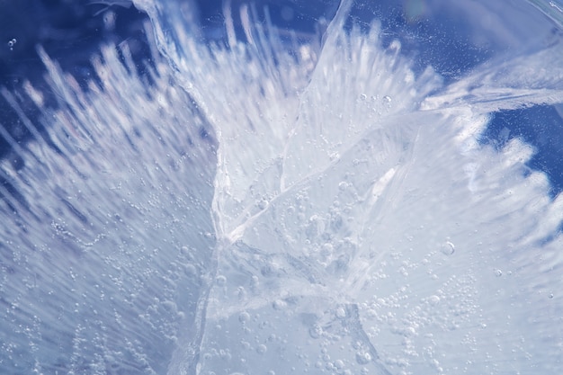 Belle glace bleue avec des fissures. fond givré