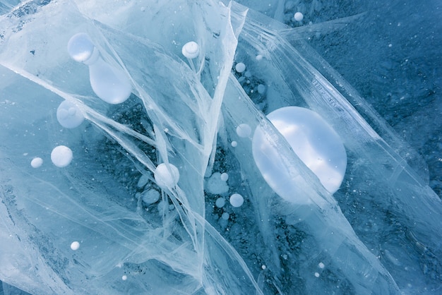 Belle glace du lac Baïkal avec des fissures abstraites et des bulles d'air gelées