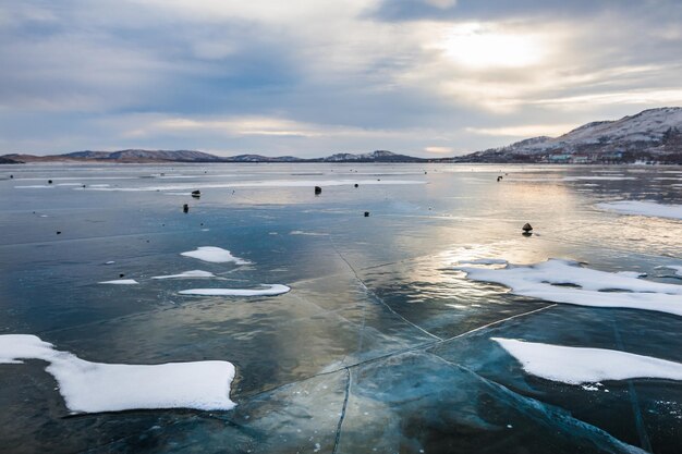 Belle glace sur le lac au coucher du soleil. Paysage d'hiver