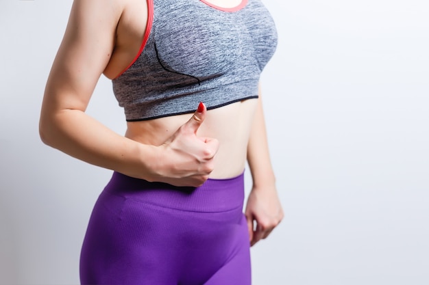 Belle grosse femme au régime qui pratique la remise en forme pour perdre du poids fait des exercices d'étirement sur un fond isolé avec un espace pour la publicité