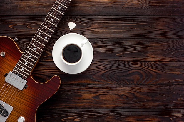 Belle guitare électrique avec un casque et un bureau de café