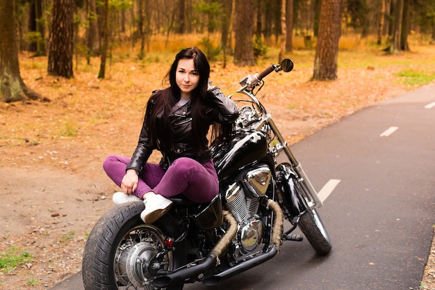 La belle et heureuse brune sur une moto