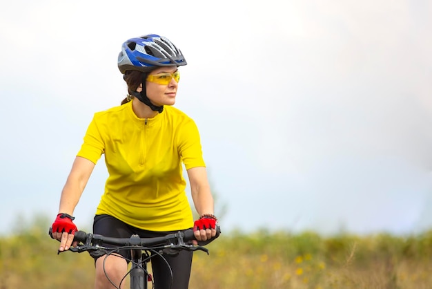 Belle et heureuse femme cycliste fait du vélo sur la route dans la nature Mode de vie sain et sports Loisirs et passe-temps