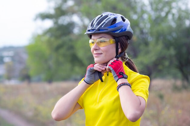 Belle et heureuse femme cycliste sur la nature. Mode de vie sain et sports. Loisirs et passe-temps