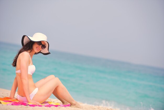 belle et heureuse femme fille sur la plage s'amuser et se détendre pendant les vacances d'été sur la magnifique mer tropicale