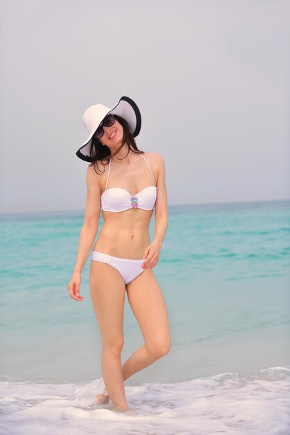 belle et heureuse femme fille sur la plage s'amuser et se détendre pendant les vacances d'été sur la magnifique mer tropicale