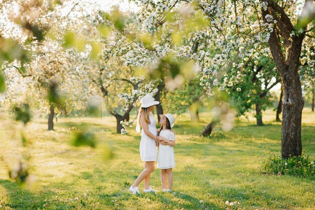 Belle et heureuse mère et fille dans un jardin de printemps en fleurs Amour parental le jour de la fête des mères