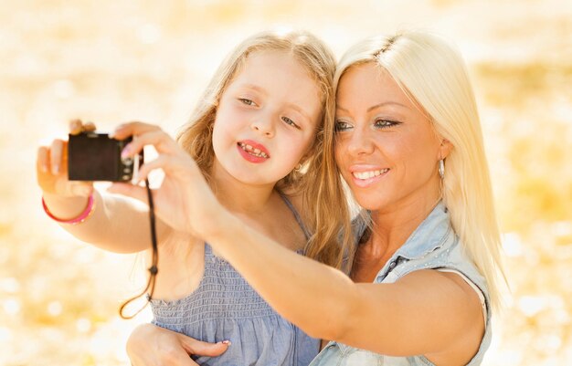 Belle et heureuse mère et fille posent pour un autoportrait dans la nature