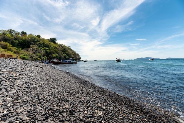 Belle île en pierre noire avec bateau à longue queue en bois sur le littoral en mer tropicale à Koh Hin Ngam