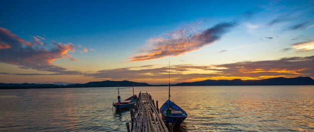 Belle image de coucher de soleil avec ciel coloré et bateau Longtail sur la mer Thaïlande