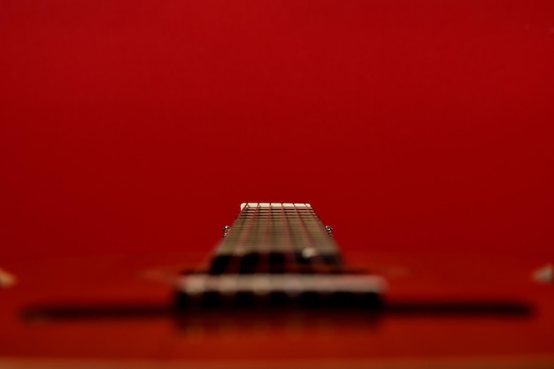 Photo belle image d'une guitare vue de profil avec un fond rouge