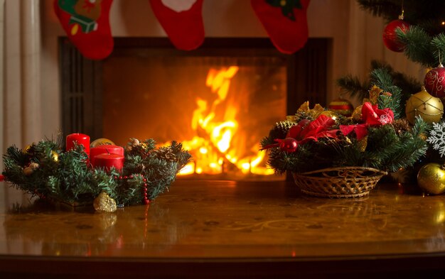 Belle Image De Table Avec Une Couronne De Noël Devant Une Cheminée En Feu Et Un Sapin De Noël Décoré. Place Vide Pour Le Texte.