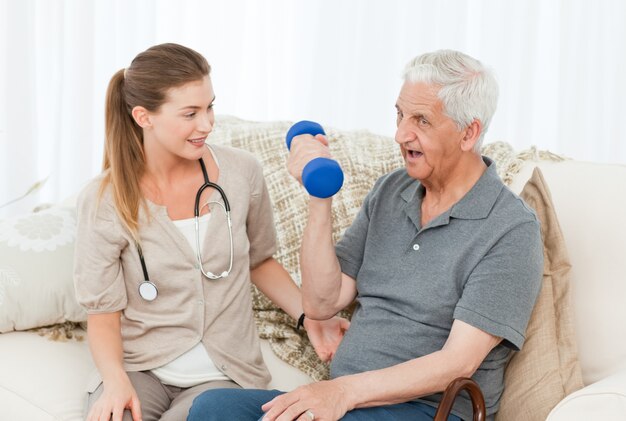 Belle infirmière aidant son patient à faire des exercices