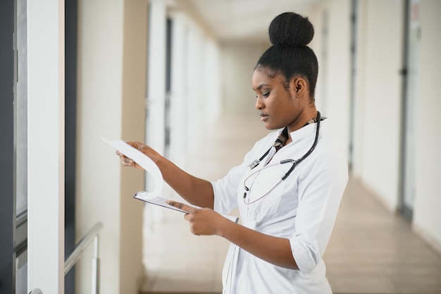 Belle infirmière pédiatrique afro-américaine dans un bureau moderne