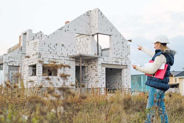 Une belle ingénieure se tient sérieuse devant un chantier de construction