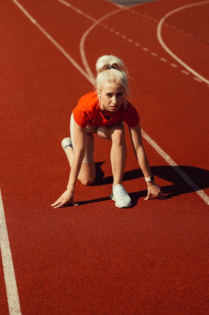 Belle jeune blonde s'apprête à courir