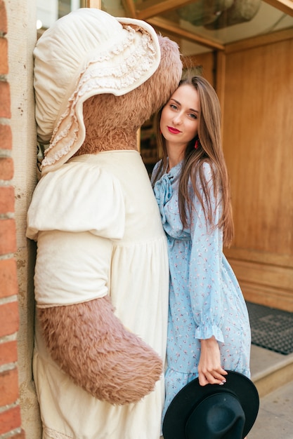 Belle jeune brune embrassant un gros ours en peluche